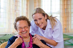 Female Nurse and elderly female patient, smiling 