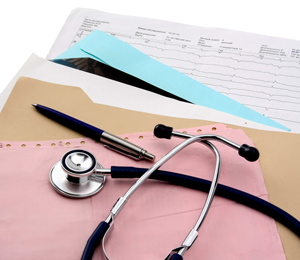 Paper work, files, a pen, and stethoscope sitting on a table 