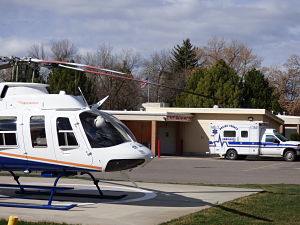 This is a picture of a helicopter and a ambulance at the emergency entrance