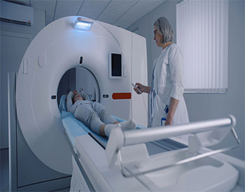 Picture of two male radiology techs and one female radiology tech standing in the x-ray room.